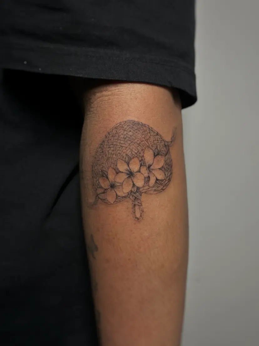 Dotwork ball with flowers tattoo on the back of an arm