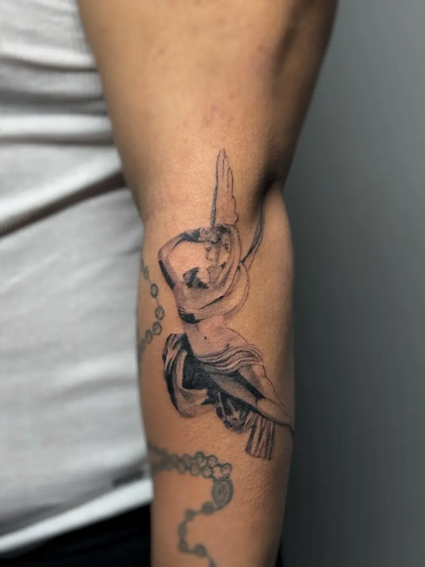 Black and grey classical statue tattoo on a forearm